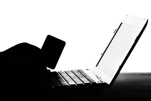 Silhouette of a man's hands with a credit card with a laptop — Stock Photo, Image