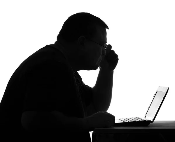 Silhueta de um homem levando um estilo de vida sedentário em um computador — Fotografia de Stock