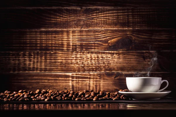 Hintergrund Kaffeetrinken in einer Tasse mit Kaffeebohnen auf Holzstruktur — Stockfoto