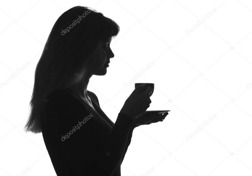 silhouette portrait of a female with a cup of drink on a saucer