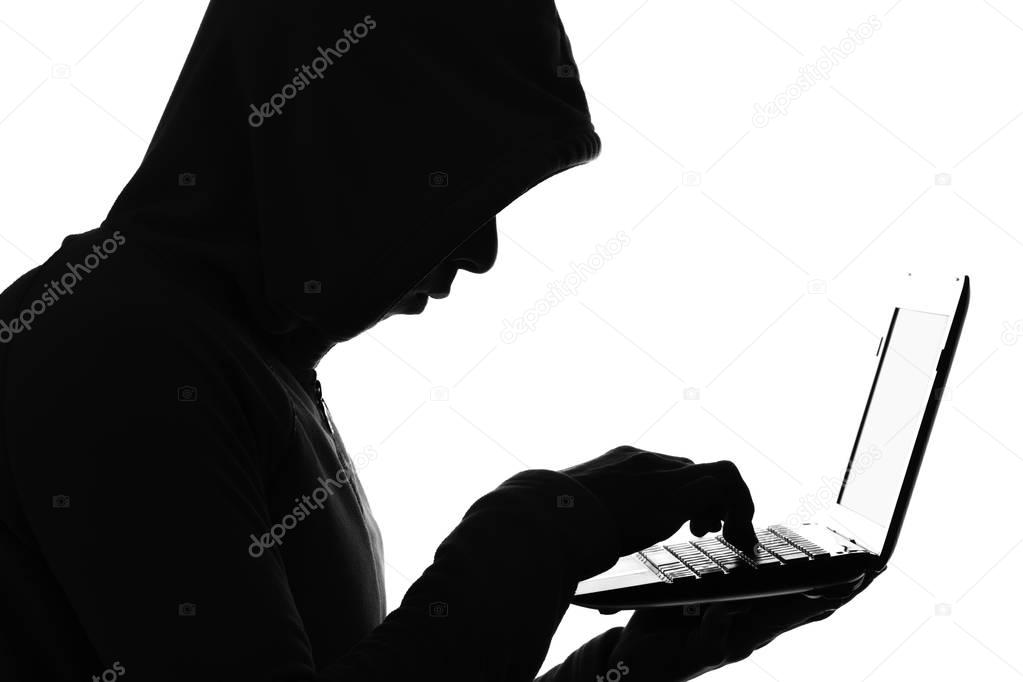 The silhouette of a hacker with netbook