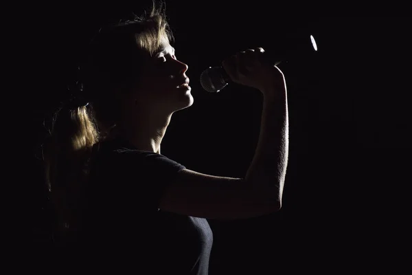 Portrait of woman singing into microphone — Stock Photo, Image