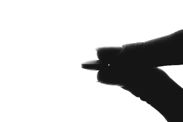 B silhueta de uma mão que mantém uma pílula — Fotografia de Stock
