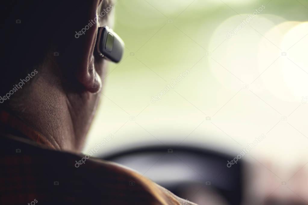 man driving a car with a bluetooth