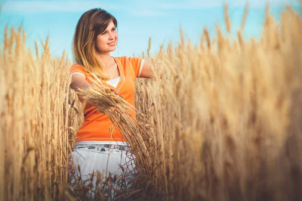 Femme assise dans un champ d'oreilles — Photo