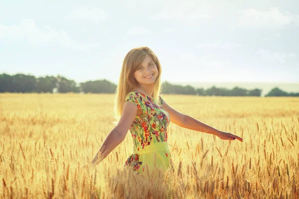 Portrait of a woman whirling on a wheat ears field at sunset Stock Image