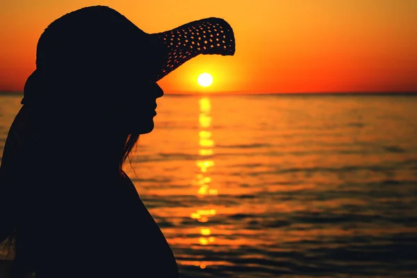 새벽 바다에서 태양 모자에 있는 여자의 실루엣 — 스톡 사진