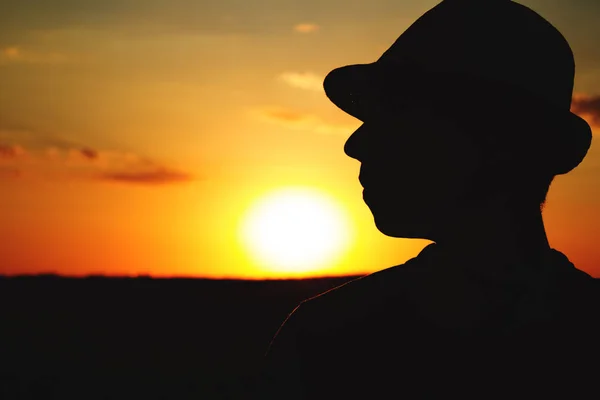 Silhueta de um agricultor masculino em chapéu em um campo — Fotografia de Stock