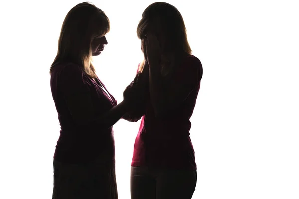 Silhouette eines weinenden Teenagers und Mutter tröstet Tochter — Stockfoto