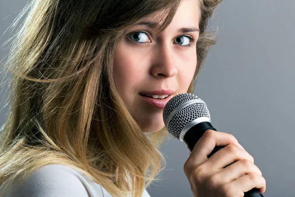 Портрет женщины, поющей в микрофон — стоковое фото