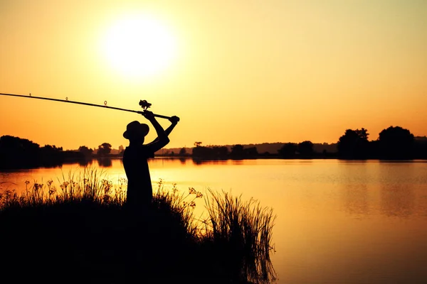 Silhouette di un pescatore che getta una mangiatoia nel fiume — Foto Stock