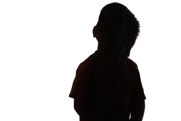 Silhouette eines kleinen Jungen, der auf weißem isoliertem Hintergrund aufblickt — Stockfoto