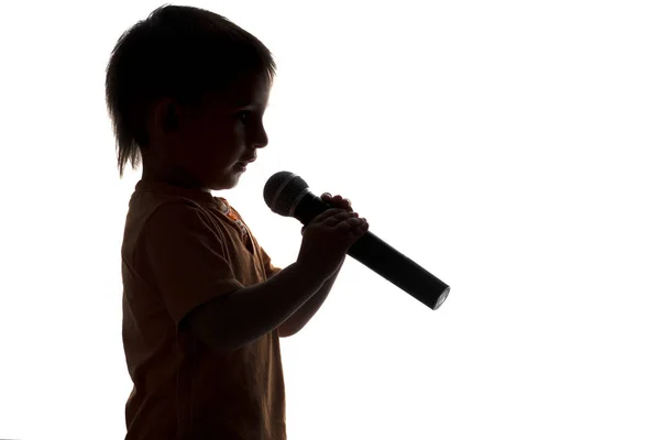 Silueta de niño cantando karaoke en el micrófono — Foto de Stock