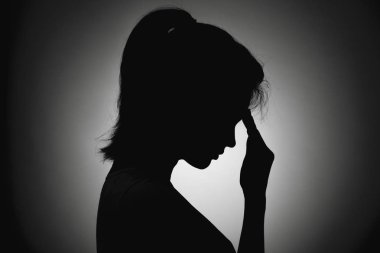 üzgün kız yüz profili, tanınmayan bir silüeti, kadında depresyon elini alnına koydu
