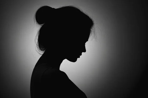 Silhouette of the face profile of an unknown sad woman, female in depression bowed her head — Stock Photo, Image