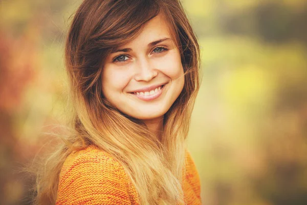 Autumn portrait of a woman face against a background of orange foliage in the park — Stock Photo, Image