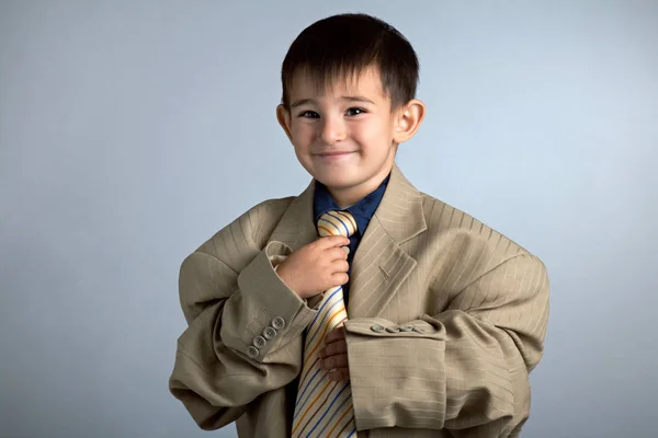 Porträt eines kleinen lustigen Jungen in Papas großem Anzug: Jacke und Krawatte — Stockfoto