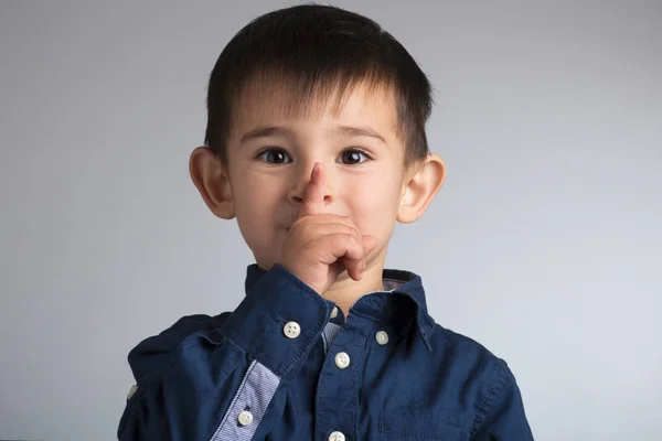 Porträt eines kleinen lustigen Jungengesichts mit einer Fingergeste: qui — Stockfoto