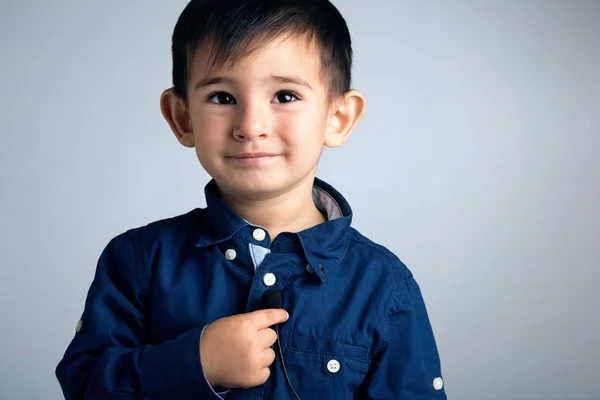 Porträt eines kleinen Jungen mit einem Mikrofon als Knopf in der Hand in der Rolle eines Telekommunikationsanbieters — Stockfoto