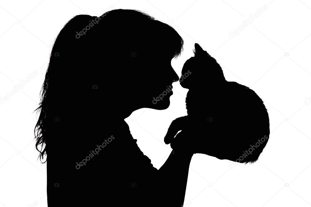 silhouette of a beautiful woman that nose to nose with a small kitten in her arms, the concept of caring for animals, favorite pets