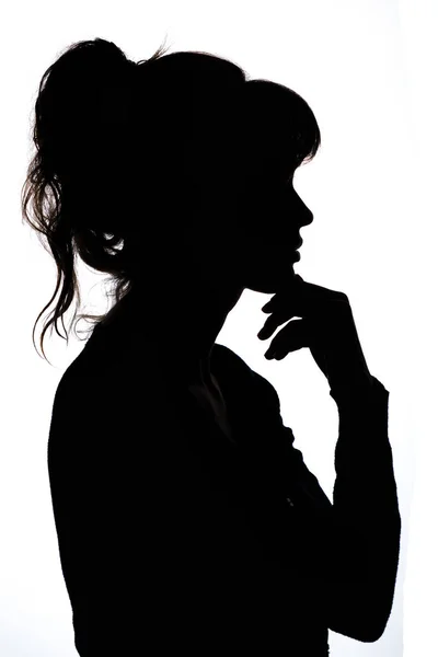 Silhouet van een doordachte vrouw met hand in de buurt van haar kin denken over het oplossen van een probleem op witte geïsoleerde achtergrond — Stockfoto