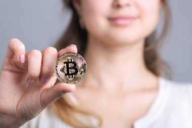 Altın bitcoin bir kripto para birimi sembolü bir elinde tutan bir gülümseyen kadın yüzü