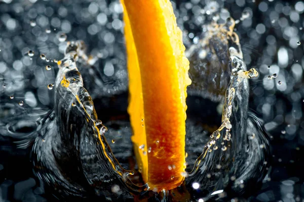 Anillo naranja con salpicaduras de agua, una fruta y salpicaduras de vitaminas — Foto de Stock