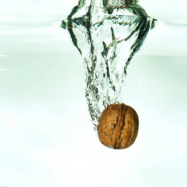Nueces en agua salpicada, concepto de alimentación saludable — Foto de Stock