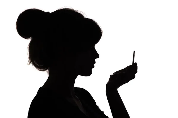 Silhouette profil d'un visage de femme regardant dans un miroir de poche, le concept de la beauté et de la mode — Photo