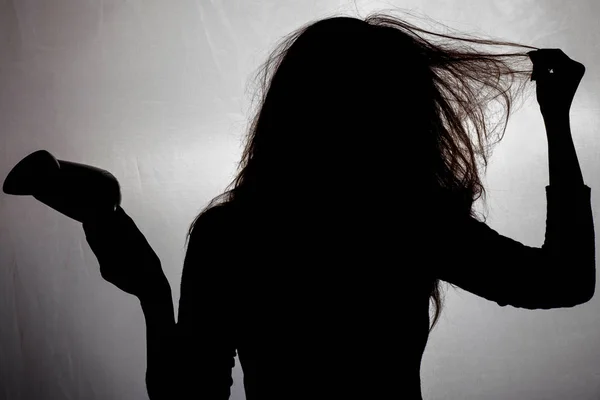 Die Silhouette einer Frau mit wirren und beschädigten Haaren mit Haaren — Stockfoto