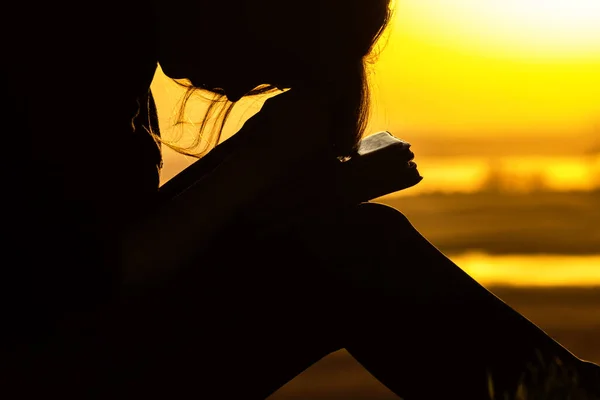Силует жінці молитися Богу в природі на захід сонця, концепція релігія й духовність — стокове фото