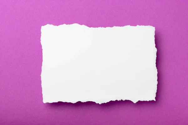 Шматок білого паперу з рваними краями на кольоровому фоні з місцем для тексту — стокове фото