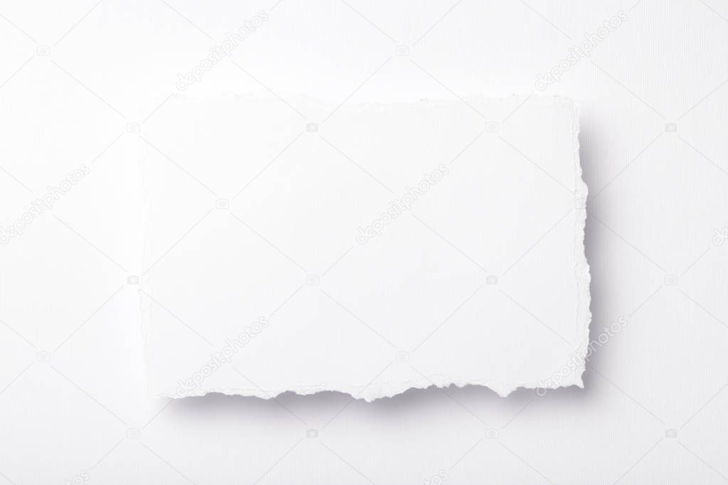 piece of white paper with torn edges on a colored background with a place for text
