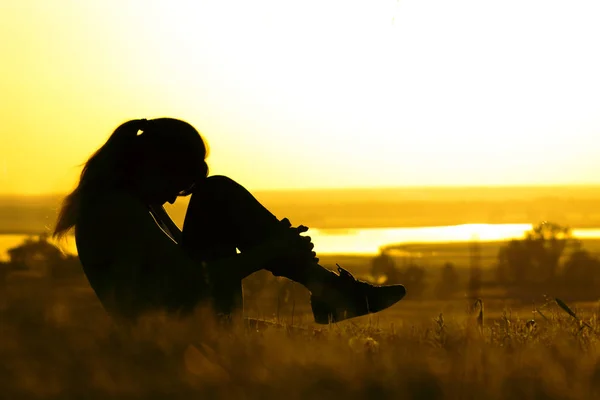 Silhouette einer Frau, die bei Sonnenuntergang in der Natur Sport treibt, Sportlerin auf dem Feld, Konzept des Sports und der Erholung — Stockfoto