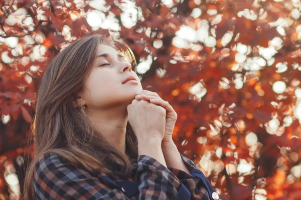 Retrato de uma jovem orando na natureza, a menina agradece a Deus com as mãos dobradas no queixo, uma conversa com o Criador, o conceito de religião — Fotografia de Stock