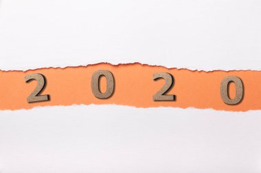 2020 tarihli ahşap figür yırtık beyaz karton şeridinin altında, yırtık kağıt turuncu delikte numaralar, yeni yıl konsepti, takvim kapağı tasarımı