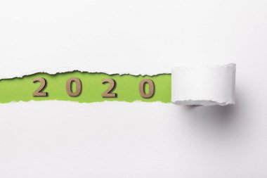 2020 tarihli ahşap figür yırtık beyaz karton şeridinin altında, yeşil yırtık kağıt deliğinde numaralar, yeni yıl konsepti, takvim kapağı tasarımı
