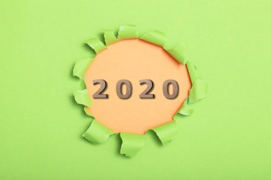 Tahta figürler karton arka plandaki yuvarlak delikte 2020 tarihli, yeni yıl konsepti, takvim kapağı tasarımı