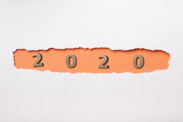 Sfondo bianco con figura in legno della data 2020 in buco arancione di cartone strappato, concetto di nuovo anno, disegno della copertina del calendario — Foto Stock