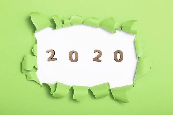 Fond de couleur verte avec figure en bois de la date 2020 dans le trou vert de carton déchiré, concept de nouvelle année, conception de couverture de calendrier — Photo