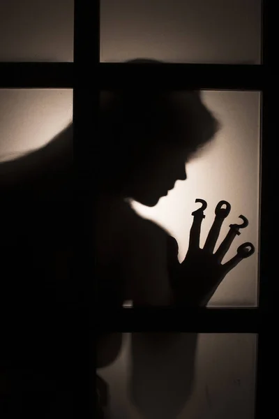 Furcsa sziluett egy női kéz dátum ujjak préselt üveg ajtó háttérvilágítással, megsemmisítése a sztereotípia boldog új évet, belépő 2020 horror műfaj — Stock Fotó