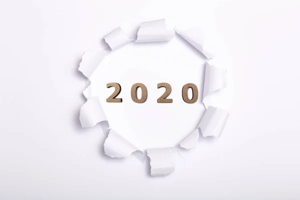 Figure di legno data 2020 in forma rotonda foro in sfondo di cartone, concetto di nuovo anno, disegno di copertina del calendario — Foto Stock