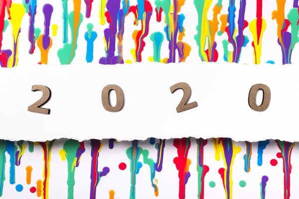 Painted abstract background with wooden figures date 2020, new year concept, calendar cover design with flowing multicolored paint — ストック写真
