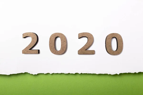 Sfondo bianco con figura in legno della data 2020 su striscia di cartone strappato verde, concetto di nuovo anno, disegno della copertina del calendario — Foto Stock