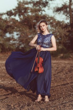 Çenesinin altında keman olan güzel bir kızın yüzü, yalnızlık, konsept müzik ve duygular üzerine müzik aleti çalan genç bir kadın.