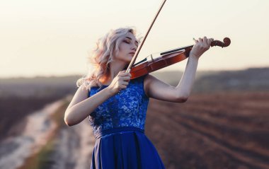 Çenesinin altında keman olan güzel bir kızın yüzü, yalnızlık, konsept müzik ve duygular üzerine müzik aleti çalan genç bir kadın.