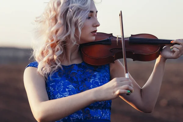 Face of a beautiful girl with a violin under her chin outdoors, young woman playing a musical instrument on nature in solitude, concept music and feelings — 스톡 사진
