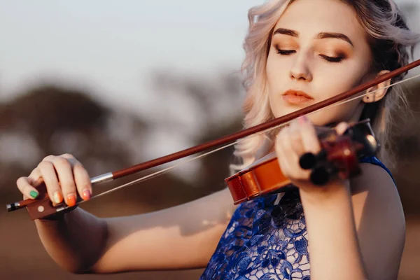 Twarz pięknej dziewczyny ze skrzypcami pod podbródkiem na zewnątrz, romantyczna młoda kobieta grająca na instrumencie muzycznym na łonie natury w samotności, konceptualnej muzyce i uczuciach — Zdjęcie stockowe