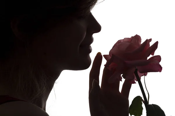 Sylwetka profil twarzy młodej szczęśliwej kobiety z różą w rękach, romantyczna dziewczyna z pączkiem kwiatu na białym odosobnionym tle — Zdjęcie stockowe