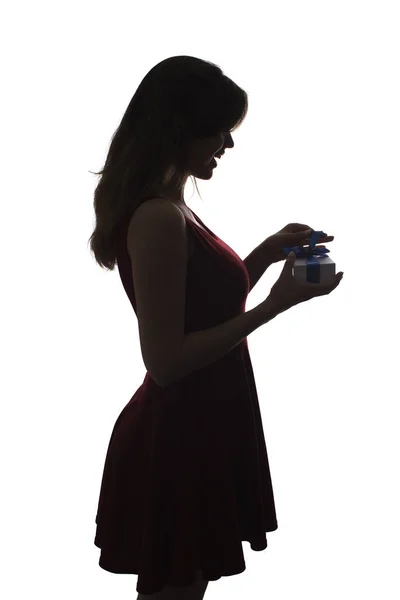 Silhouette of a young woman with a gift in hands, girl with a box with a bow on a white isolated background,concept of holidays — Stock Photo, Image